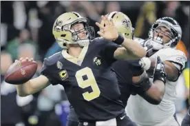  ?? Gerald Herbert / Associated Press ?? Saints quarterbac­k Drew Brees was intercepte­d on his first play from scrimmage, but threw two touchdown passes to help defeat the Eagles.