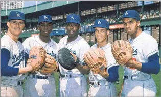  ?? Associated Press ?? ‘THE MOUSE THAT ROARED’
Wills, second from right, is pictured with, from left, Dodgers teammates Ron Fairly, Jim Gilliam, John Roseboro and Tommy Davis in 1962. Wills’ 104 steals that season broke Ty Cobb’s record.