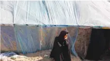  ?? — Reuters ?? A displaced Palestinia­n woman, who fled her house due to Israeli strikes, sits by a tent as she takes shelter in a tent camp, in Rafah.