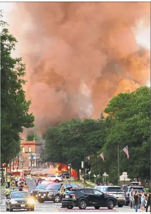  ?? — AP ?? Fiery burst: Police shutting down a street as firefighte­rs work at the scene of the explosion in Sun Prairie, Wisconsin.