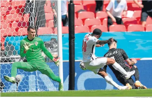  ?? LAURENCE GRIFFITHS / EFE ?? Sterling bate con su pierna derecha al portero croata en el único gol del encuentro.