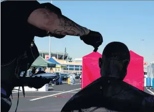  ?? AP PHOTO ?? A homeless man, who declined to give his name, gets a free haircut in the parking lot of Angel Stadium during the community outreach day in Anaheim, Calif. The event was organized by non-profit organizati­ons and agencies to offer services to homeless...