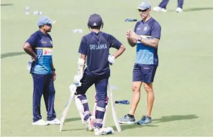  ?? Agence France-presse ?? Sri Lanka’s coach Nic Pothas (right) talks with Rangana Herath (left) and another player during a practice session at the Eden Gardens in Kolkata on Tuesday.