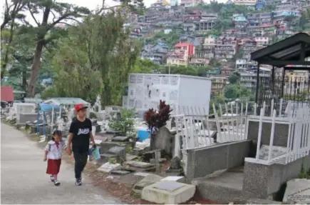  ?? Photo by Milo Brioso ?? PASSING THROUGH. Residents and use the Baguio cemetery road enroute to Central Business District as short cut.