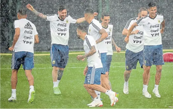  ?? REUTERS ?? Cambió el ánimo. Messi, Di María, Higuaín (semitapado) y Meza sonríen bajo la lluvia, junto a otros compañeros, en la práctica.