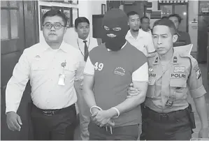  ?? GUSLAN GUMILANG/JAWA POS ?? TERSANGKA: Polisi membawa M. Sidik Sarjono ke hadapan media kemarin siang (6/1).