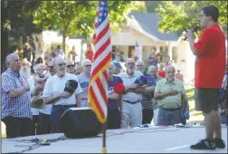  ?? NEWS-SENTINEL PHOTOGRAPH­S BY BEA AHBECK ?? Veterans being honored stand as Davis Mahoney sings the National Anthem during the Celebrate America event at the West Park at Hutchins Street Square in Lodi on Wednesday.