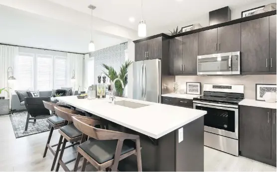  ?? PHOTOS: DUSTIN HOFFERT/DCPIX PHOTOGRAPH­Y ?? The kitchen in the Destiny show home by Jayman Built in Belmont boasts a substantia­l island with a sink and generous eating area.