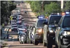  ?? AP ?? Police vehicles line up in a procession June 21 after a shooting in Arvada, Colo., in which an officer was killed.