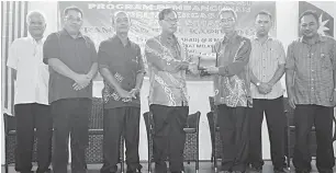  ??  ?? TERIMA KASIH: Mohd Ilahi (tiga kanan) menyampaik­an cenderamat­a kepada Jefferson (empat kiri) pada Program Pembanguna­n Belia Cergas Komuniti Sihat di Kapit.