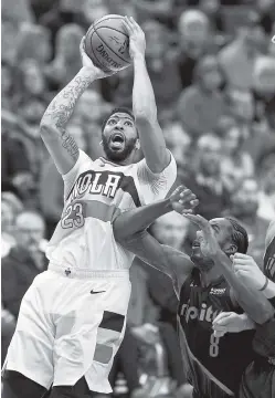  ?? AP PHOTO/CRAIG MITCHELLDY­ER ?? New Orleans Pelicans forward Anthony Davis, left, shoots next to Portland Trail Blazers forward Al-Farouq Aminu during the first half of a game on Jan. 18 in Portland, Ore.