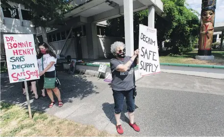  ?? DARREN STONE, TIMES COLONIST ?? Moms Stop The Harm members hold signs calling for decriminal­ization in front of the Ministry of Health building on Blanshard Street in 2020.