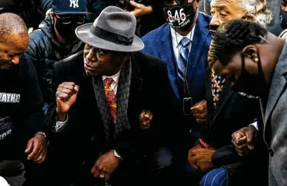  ?? Stephen Maturen / Getty Images ?? Attorney Ben Crump, center, takes a knee with members of George Floyd’s family and the Rev. Al Sharpton for 8 minutes and 46 seconds outside the Hennepin County Government Center in Minneapoli­s.