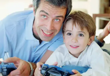  ??  ?? La sfida Padre e figlio intenti in un’avvincente partita alla consolle della play station. La Sony non ha ancora annunciato l’uscita della versione 5