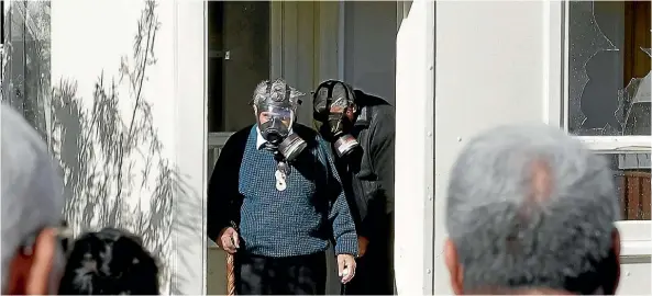  ?? PHOTO: MAARTEN HOLL/FAIRFAX NZ ?? After the standoff ended, the family of Pita Te Kira, as well as friends and community members, gathered outside as local kaumatua donned gas masks and went inside 13A Kokiri Cres to bless each room.