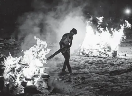  ?? Getty Images ?? A worker helps cremate the bodies of people who died from COVID-19 on the banks of the Ganges River in Allahabad, India.