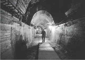  ?? JANEK SKARZYNSKI/AFP/GETTY IMAGES ?? Men on Friday walk in undergroun­d galleries under Ksiaz Castle, in the area where a Nazi gold train is supposedly hidden in Walbrzych, Poland.