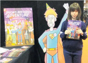  ??  ?? Comic Caitlin proudly shows off the new comic at a recent convention, and hopes it will be released