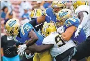  ?? Myung J. Chun Los Angeles Times ?? UCLA RUNNING BACK Christian Grubb rumbles for a seven-yard touchdown in the fourth quarter.