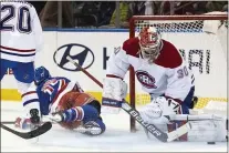  ?? JESSIE ALCHEH — THE ASSOCIATED PRESS ?? Montreal goaltender Cayden Primeau, right,blocks the puck after defenseman Chris Wideman, left, tripped up Rangers center Kevin Rooney on Tuesday.