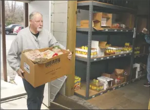  ?? The Sentinel-Record/Richard Rasmussen ?? DONATIONS ACCEPTED: Volunteer Rick Ellis, of Hot Springs Village, carries a box of donated items into the Project HOPE Food Bank on Gaines Street Monday. Donations will be accepted for the food bank today as admission into the Holiday in the Park event at 6 p.m. in Horner Hall.