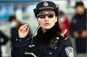  ?? — AFP ?? A police officer wearing a pair of smartglass­es with a facial recognitio­n system in Zhengzhou in China.