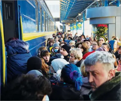  ?? PIERRE CROM / GETTY IMAGES ?? Residents of Kyiv, capital of Ukraine, try on Feb 26 to board a train evacuating people to the country’s western regions. Explosions and gunfire were reported around Kyiv during the fighting in Ukraine.