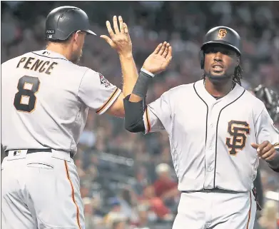  ?? CHRISTIAN PETERSEN — GETTY IMAGES ?? The Giants’ Alen Hanson is congratula­ted by Hunter Pence after scoring in the fifth inning of Sunday’s 9-6 win over Arizona.