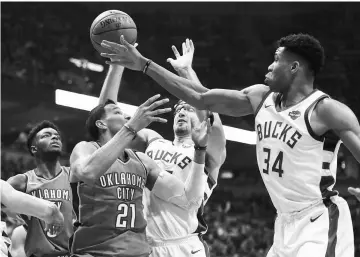  ??  ?? Oklahoma City Thunder guard Andre Roberson (second left) and Milwaukee Bucks forward Giannis Antetokoun­mpo (right) battle for a rebound in the second quarter at BMO Harris Bradley Centre. — USA TODAY Sports