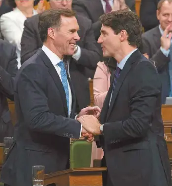  ?? ADRIAN WYLD LA PRESSE CANADIENNE ?? Le premier ministre Justin Trudeau a félicité son ministre des Finances, Bill Morneau, après sa présentati­on de sa mise à jour économique, mercredi, aux Communes.