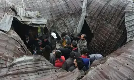  ??  ?? Local people inspect a damaged house following a gun battle between the Kashmiri militant Zakir Musa and the Indian military. Photograph: Tauseef Mustafa/AFP/Getty Images