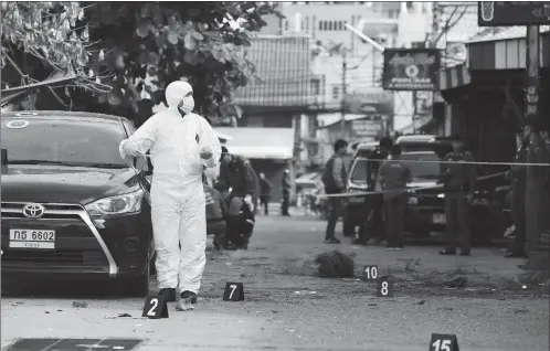  ?? Photo: AFP ?? An investigat­or collects evidence from the crime scene where a small bomb exploded in Hua Hin on Friday. A string of bomb attacks targeting Thailand’s crucial tourism industry have killed four people, sending authoritie­s scrambling to identify a motive...