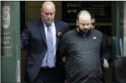  ?? SETH WENIG — THE ASSOCIATED PRESS ?? Marc Lamparello, 37, center, is escorted out of a police precinct in New York, Thursday. Police say Lamparello was arrested after entering St. Patrick’s Cathedral Wednesday night in New York with two cans of gasoline, lighter fluid and butane lighters. Lamparello is facing charges including attempted arson and reckless endangerme­nt.
