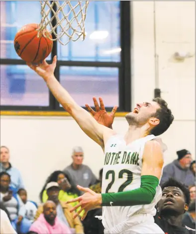  ?? Christian Abraham / Hearst Connecticu­t Media ?? Notre Dame-West Haven’s Connor Raines lays up the ball for two points during the Winter Snow Jam Christmas tournament final in West Haven on Saturday.