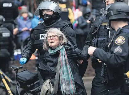  ?? Picture / AP ?? A woman is detained in Portland, Oregon yesterday as thousands of demonstrat­ors across the country took part in a President’s Day protest dubbed Not My President's Day.