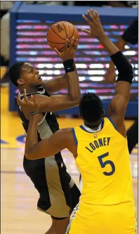  ?? EZRA SHAW/GETTY IMAGES ?? De'Aaron Fox of the Sacramento Kings shoots over Kevon Looney of the Golden State Warriors on Jan. 4 in San Francisco.