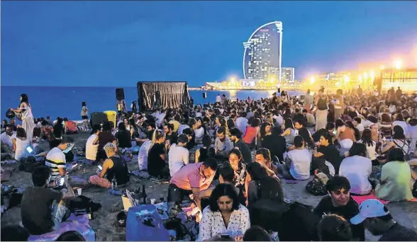  ?? ÀLEX GARCIA ?? La playa de Sant Sebastià atestada de personas al ritmo de una velada musical que se celebró en la arena