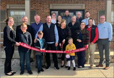  ?? Staff photo/Corey Maxwell ?? Laura Roetgerman, surrounded by her family, center employees, minster and county officials, cuts the ‘grand opening’ ribbon on tuesday evening for the center for personal wellness, located at 4 eagle drive in minster.