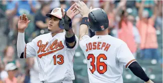  ?? AP ?? Manny Machado es felicitado por Caleb Joseph tras pegar su jonrón 24 en el triunfo de los Orioles de Baltimore 6-5 sobre los Vigilantes de Texas.