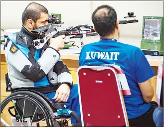  ??  ?? Kuwait’s Atef Aldousari (left), competes in the R4-mixed 10m air rifle standing competitio­n at the 2018 Asian ParaGames in Jakarta on Oct 10. (AFP)