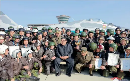  ?? AP ?? North Korean leader Kim Jong Un, front centre, poses with pilots during his inspection of a flight demonstrat­ion of military aircraft.