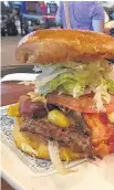  ?? Misha Govshteyn ?? A towering cheeseburg­er at Guy Fieri’s American Kitchen and Bar in Cancun Internatio­nal Airport.