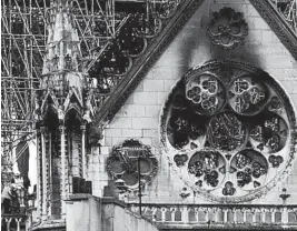  ?? KAMIL ZIHNIOGLU/AP ?? Experts inspect the damaged Notre Dame cathedral Tuesday in Paris after Monday’s fire.