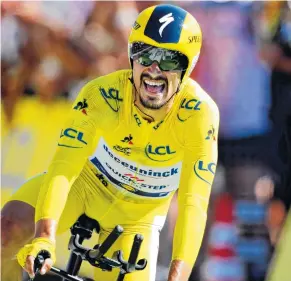  ?? AP PHOTO/CHRISTOPHE ENA ?? France’s Julian Alaphilipp­e, wearing the overall leader’s yellow jersey, crosses the finish line to win the 13th stage of the Tour de France on Friday in Pau, France.