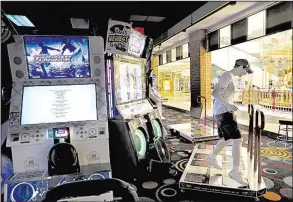  ?? Chicago Tribune/ANTONIO PEREZ ?? Mall visitor Kilroy Massa dances on an arcade game at the Stratford Square Mall in Bloomingda­le, Ill., near Chicago, last week. The mall includes a mix of retail shops, entertainm­ent and businesses not typically located in malls.