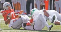  ?? JAY LAPRETE/ASSOCIATED PRESS FILE PHOTO ?? Ohio State quarterbac­k C.J. Stroud, left, is sacked by Oregon defensive end DJ Johnson, center, and defensive lineman Brandon Dorlus on the final play of Saturday’s game in Columbus, Ohio. Oregon beat Ohio State 35-28.