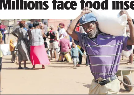  ?? Photo: Nampa ?? Dire… An unidentifi­ed Dordabis resident carries away his share of the maize meal donated as part of the drought relief programme.