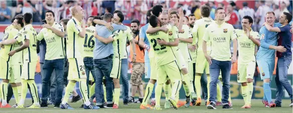  ??  ?? CAMPEONES: Barcelona’s players celebrate after winning the club’s fifth La Liga title in seven years following a 1-0 win over Atelico Madrid at the Vicente Calderon stadium on Sunday. The winning goal came from Lionel Messi and secured the first part...