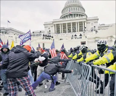  ??  ?? A DAY OF SHAME: Protesters who earlier had heard President Trump speak push barricades toward initially outmanned Capitol Police. Reinforcem­ents, including the National Guard, were eventually called in.