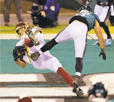  ?? RICH SCHULTZ/ASSOCIATED PRESS ?? Tight end Logan Thomas catches a 13-yard touchdown pass from Alex Smith despite defense by Philadelph­ia’s T.J. Edwards late in the second quarter Sunday. The play put Washington ahead to stay in its 20-14 NFC East-clinching victory.